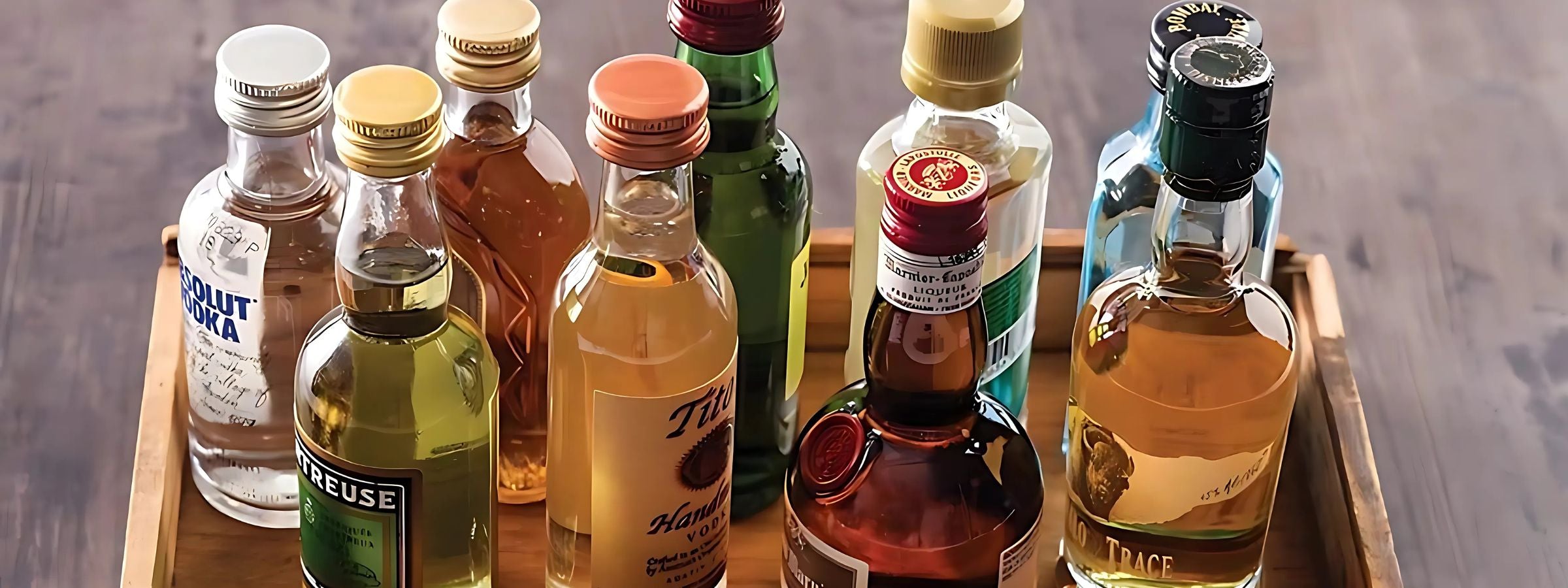 Assorted miniature alcohol bottles (spirits and wine) arranged on a gift tray or shelf