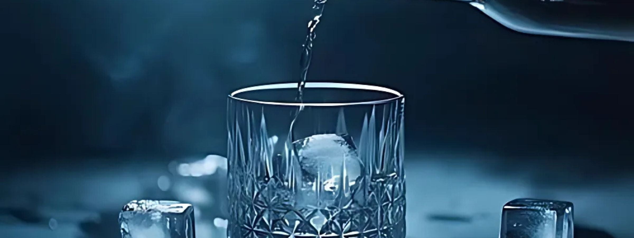 Assorted vodka bottles with flavoured variants, cocktail glass and ice on a modern bar setup