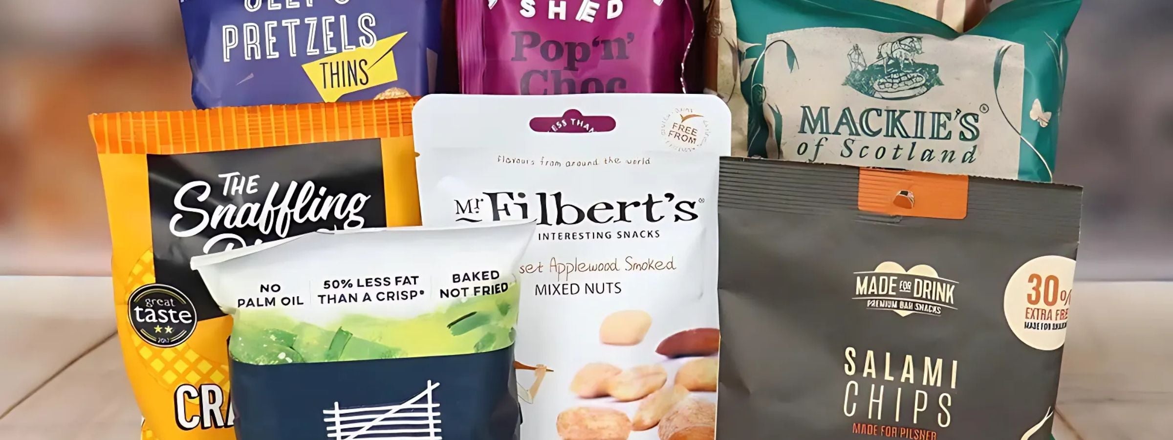 Assorted snacks including popcorn, crisps and chocolates arranged beside wine and spirits