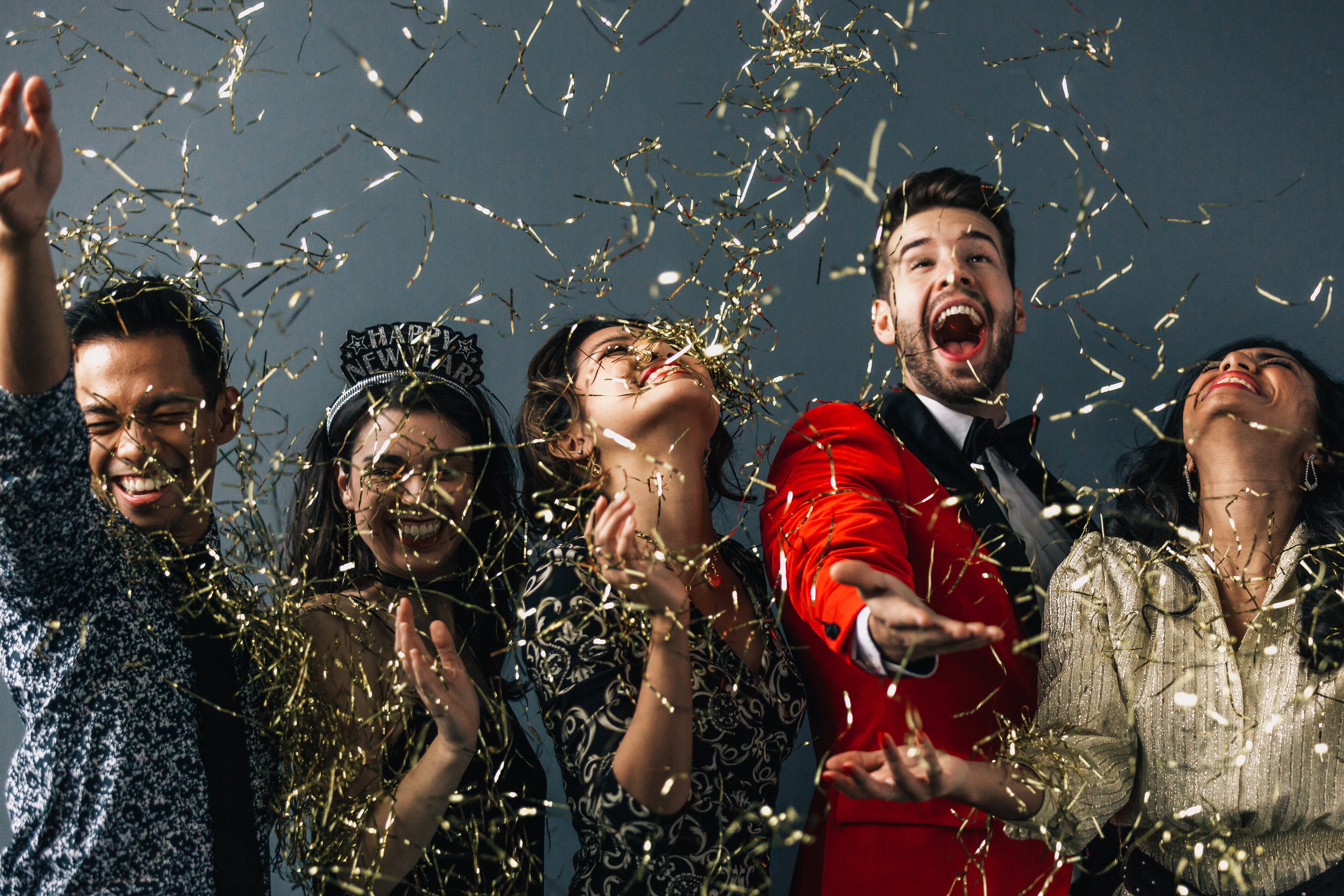 Group of young adults celebrating with confetti and drinks at a party, representing bulk drink orders for events and corporate celebrations.