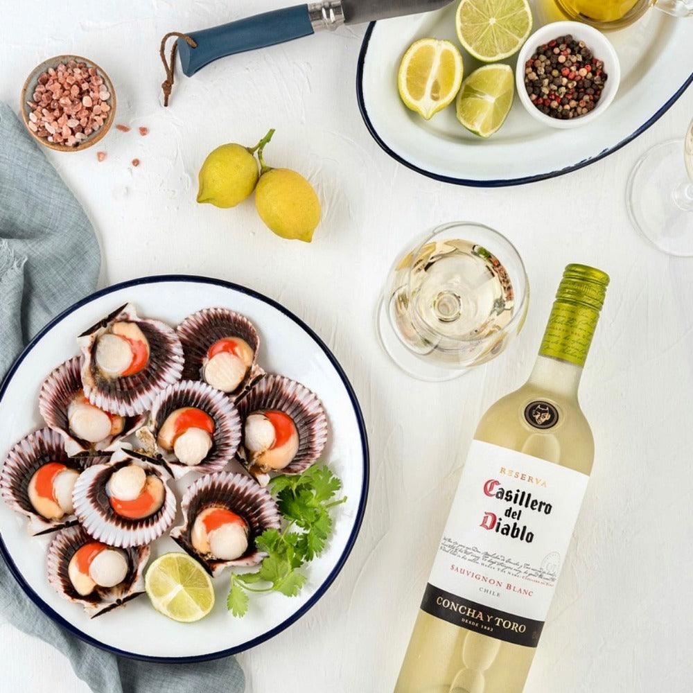 Casillero del Diablo Sauvignon Blanc 75cl bottle with chilled glass and citrus slices on outdoor table