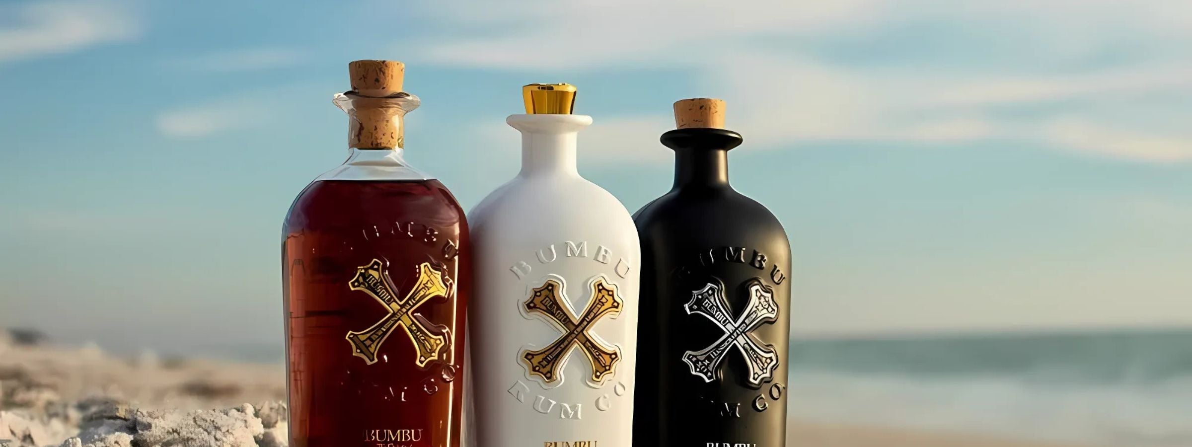 Bumbu rum bottles (Original, XO, Créme) with glass, dark tropical wood table and spice garnish