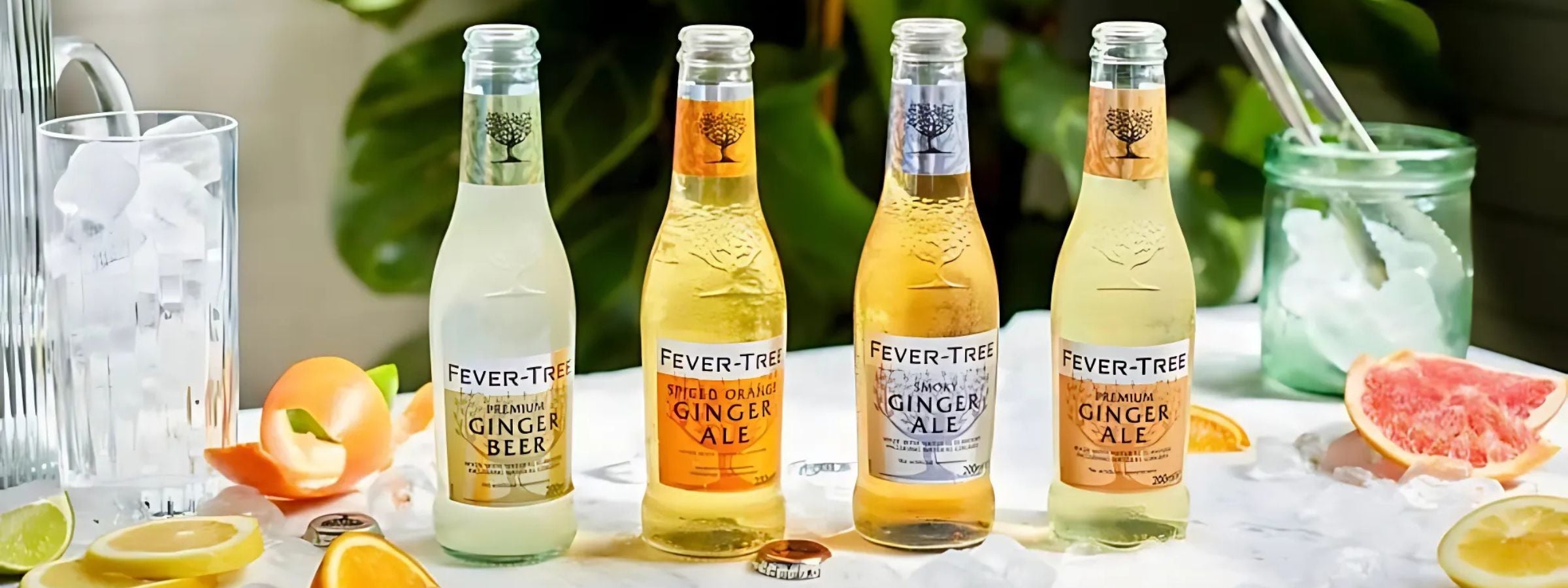 Fever-Tree tonic bottles and cans arranged beside cocktail ingredients and spirits